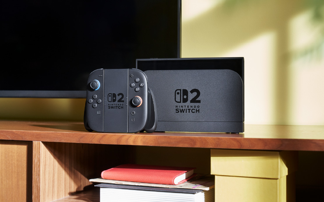 A Nintendo Switch 2 on a console in front of a TV.